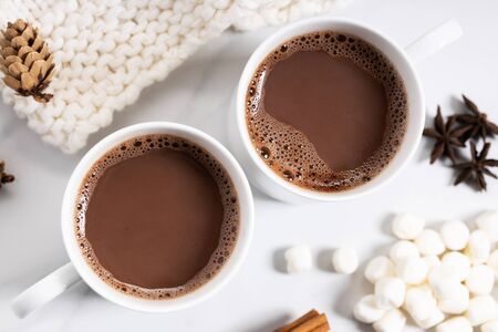 White ceramic cups of hot cocoa on top of white marble background, top viewの写真素材
