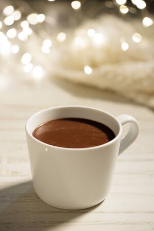 White ceramic cup of hot cocoa on white wooden backgroundの写真素材