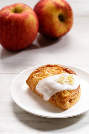 piece of cinnamon apple pie on a white plate with fresh apple in background, autumn food conceptの写真素材
