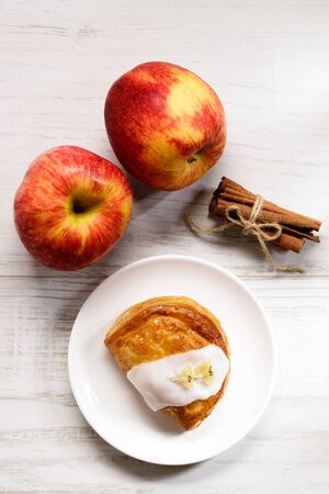 piece of cinnamon apple pie on a white plate with fresh apple in background, autumn food conceptの写真素材