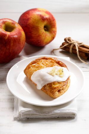 piece of cinnamon apple pie on a white plate with fresh apple in background, autumn food conceptの写真素材