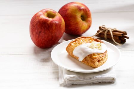 piece of cinnamon apple pie on a white plate with fresh apple in background, autumn food conceptの写真素材