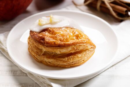 piece of cinnamon apple pie on a white plate with fresh apple in background, autumn food conceptの写真素材