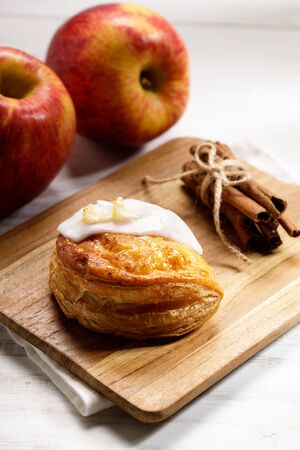 piece of cinnamon apple pie on a wooden board with fresh apple in background, autumn food conceptの写真素材