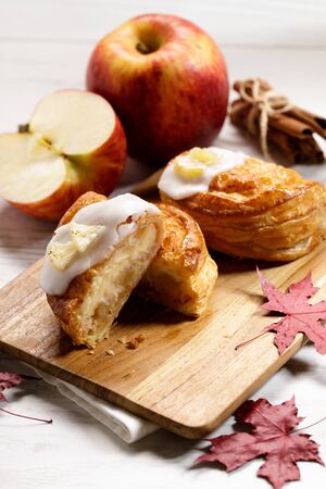 piece of cinnamon apple pie on a wooden board with fresh apple in background, autumn food conceptの写真素材