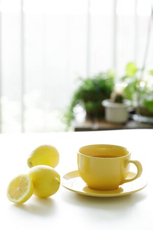 a cup of tea with fresh yellow lemons on white backgroundの写真素材