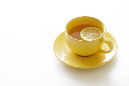 a cup of tea with fresh yellow lemons on white backgroundの写真素材