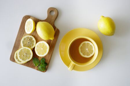 a cup of tea with fresh yellow lemons on white backgroundの写真素材