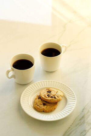 Two cups of coffees on white marble table in morning lightの写真素材