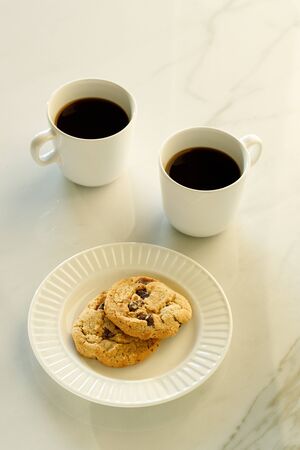 Two cups of coffees on white marble table in morning lightの写真素材