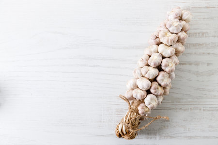 Ripe organic garlic clove and bulb on white wooden background.  Close-up. Selective focus.の写真素材