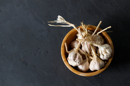 Ripe organic garlic clove and bulb on black stone background.  Close-up. Selective focus.の写真素材