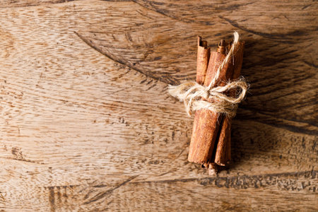 Cinnamon sticks dried tree bark spice on rustic wooden table background. Selective focus.の写真素材