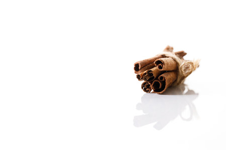 Cinnamon sticks dried tree bark spice on white table background. Selective focus.