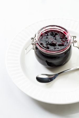 Jar of blueberry jam on white marble table background. Selective focus.の写真素材