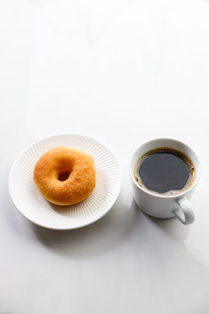 Cup of black coffee, Donut on white marble background. Copy space.