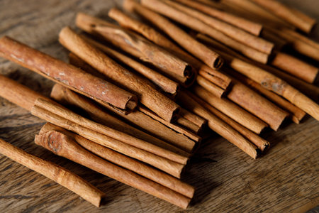 Cinnamon sticks dried tree bark spice on rustic wooden table background. Selective focus.