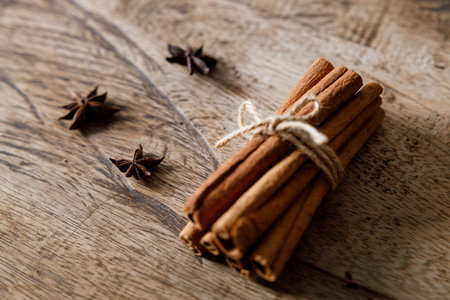 Cinnamon sticks dried tree bark spice on rustic wooden table background. Selective focus.の写真素材