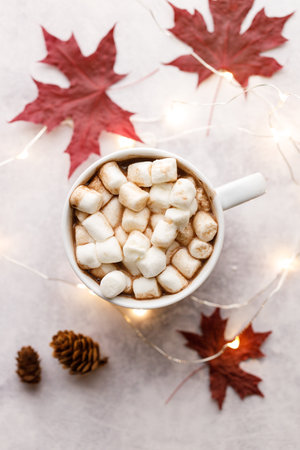 Cup of delicious hot chocolate and marshmallows under warm light on white table background. Selective focus.の写真素材
