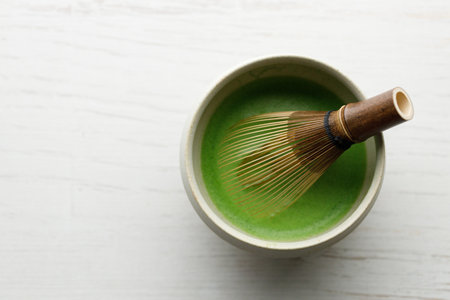 Cup of fresh matcha tea, green tea on white wooden table. Top view.の写真素材