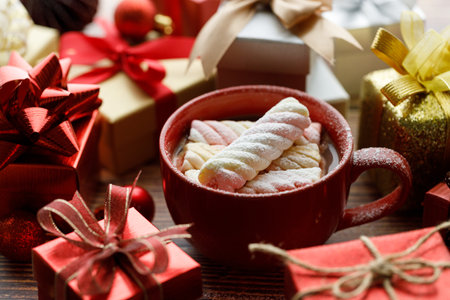 Cup of delicious hot chocolate and assorted artisanal gift boxes tied with bows, Christmas decorations on wooden background. Christmas New year concept. Selective focus.の写真素材