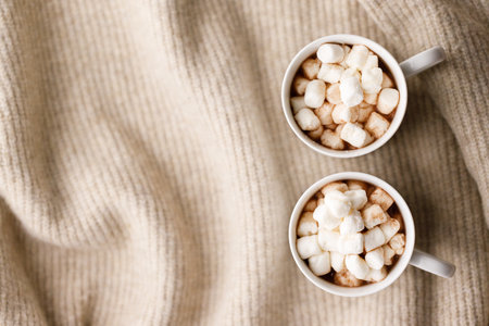 Cups of delicious hot chocolate on warm sweater. Christmas New year concept. Selective focus. top viewの写真素材