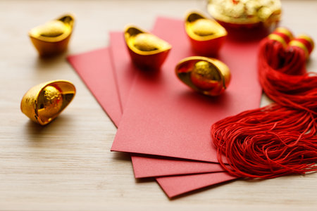 Red envelope and golden ingot or Yuanbao on wooden background for celebration happy Lunar New Year or Chinese New Year. Selective Focus.の写真素材