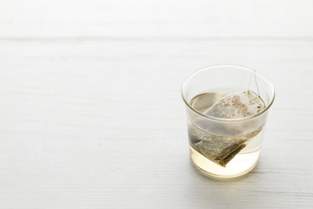 Cup of hot tea with tea bag on white wooden table. selective focus.の写真素材