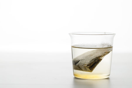 Cup of hot tea with tea bag on white wooden table. selective focus.の写真素材