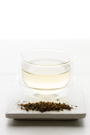 Cup of hot tea blended from rooibos, spearmint, apple, baobab on white wooden table. selective focus.の写真素材