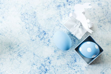 Happy Easter eggs and gift boxes on white and blue background. Easter decoration Selective focus.の写真素材