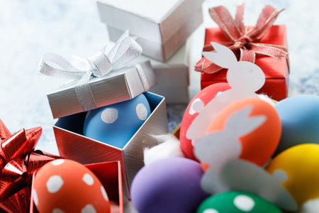 Happy Easter eggs and gift boxes on white and blue background. Easter decoration Selective focus.