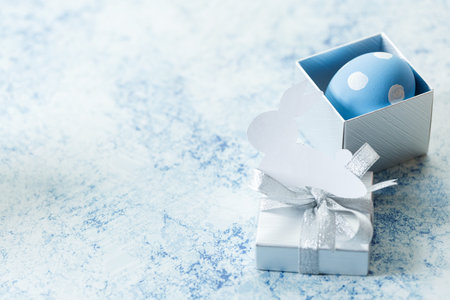 Happy Easter eggs and gift boxes on white and blue background. Easter decoration Selective focus.