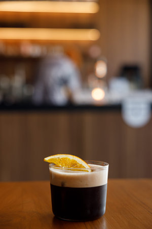 Cup of creation coffee Mocktail drink decorated with orange on wooden table. Selective focus.