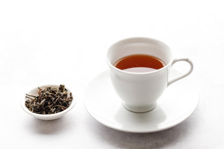 Cup of hot tea with tea leaf on white table background. selective focus.の写真素材