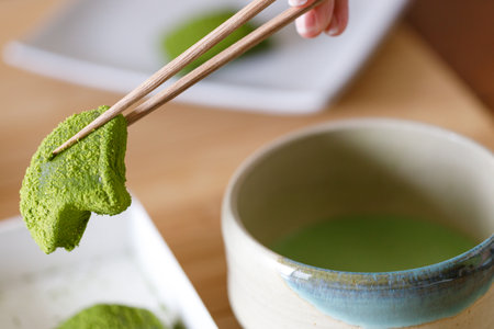 Cup of fresh matcha tea and Warabi mochi, traditional Japanese sweet from bracken starch on wooden table. Selective focus.の写真素材
