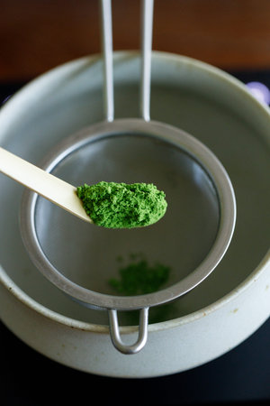 Closeup of fresh matcha powder, green tea powder, Chashaku, matcha scoop and Chawan, matcha bowl....