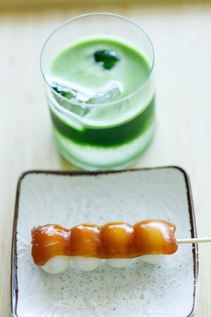 Glass of fresh matcha tea, green tea with coconut water and Mitarashi dango, traditional Japanese...