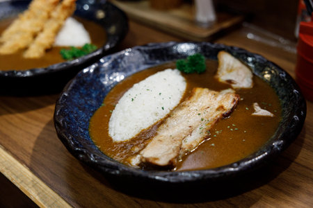 Delicious Japanese style curry rice topped with pork belly on plate.の写真素材