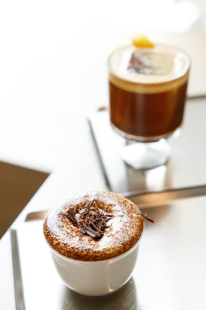 Cup of hot milk chocolate mocha coffee and creation black coffee on table by the window. Selective focus.の写真素材