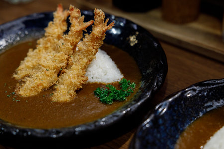 Delicious Japanese style curry rice topped with deep fried shrimp on plate. Selective focus.の写真素材