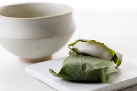 Kashiwa mochi and Cup of fresh matcha tea. Japanese sweet from mochi or rice cake and sweet red bean...