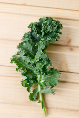 Fresh green Kale leaf salad vegetable on wooden background. Selective focus.