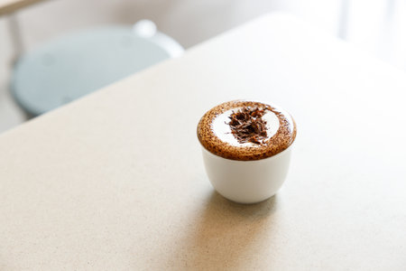 Cup of hot milk chocolate mocha coffee on table by the window. Selective focus.の写真素材