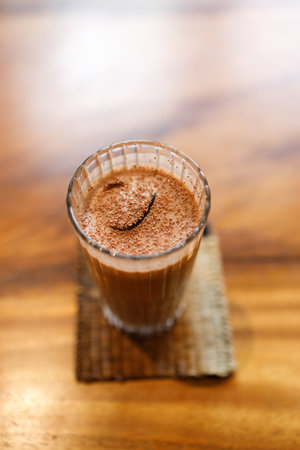 Cup of delicious iced chocolate on wooden table background by the window. Selective focus.の写真素材
