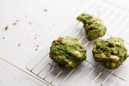 Closeup of fresh baked matcha cookies on white wooden background. Selective focus.