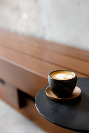 Cup of milk piccolo latte coffee on table by the street. Selective focus.