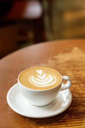 Cup of hot milk latte coffee on table by the window. Selective focus.の写真素材
