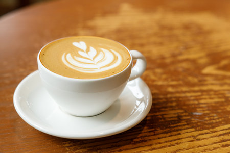Cup of hot milk latte coffee on table by the window. Selective focus.の写真素材