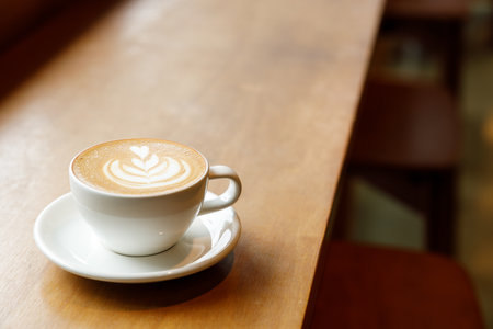 Cup of hot milk latte coffee on table by the window. Selective focus.の写真素材